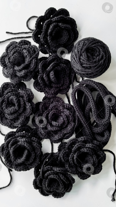 Скачать Черные вязаные цветы и пряжа на белом фоне фотосток Ozero
