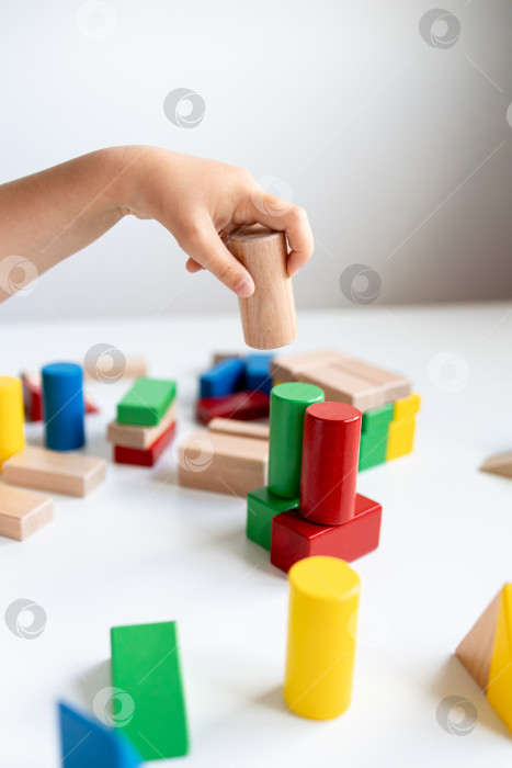 Скачать Ребенок играет с разноцветными деревянными кубиками фотосток Ozero