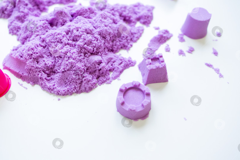 Скачать Фиолетовый кинетический песок с рельефными формами на белой поверхности фотосток Ozero