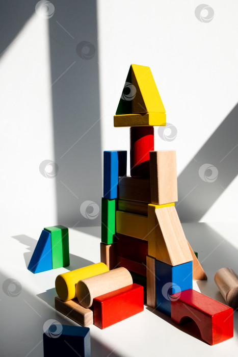 Скачать Красочная башня из деревянных блоков в залитой солнцем комнате фотосток Ozero