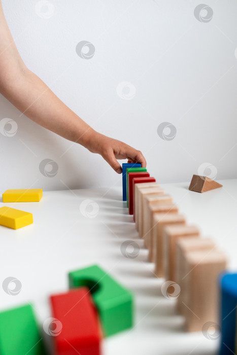 Скачать Ребенок играет с разноцветными кубиками в креативном домино фотосток Ozero