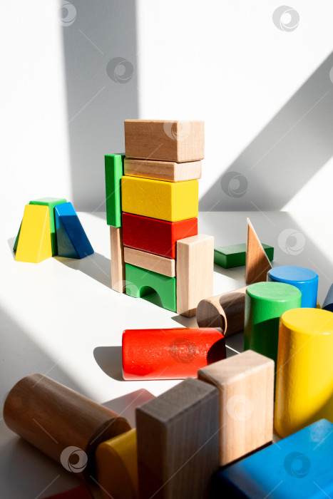 Скачать Разноцветные деревянные блоки возвышаются в залитой солнцем комнате с тенями фотосток Ozero