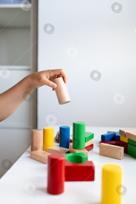 Скачать Ребенок занимается с красочными деревянными кубиками для практических игр и обучения фотосток Ozero