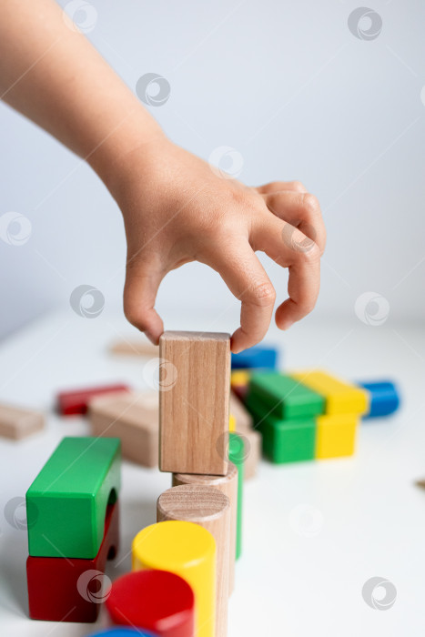 Скачать Ребенок играет с разноцветными деревянными кубиками фотосток Ozero