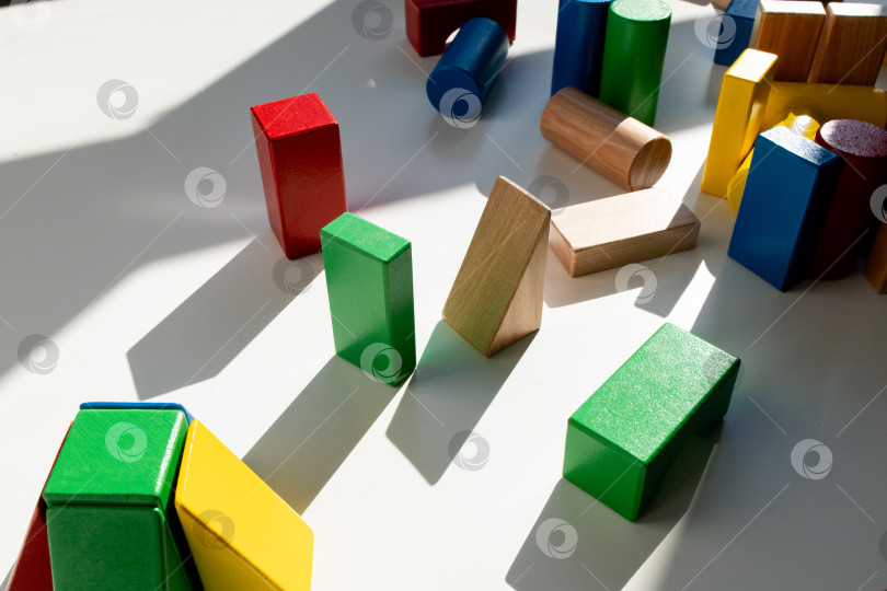 Скачать Разноцветные деревянные блоки в солнечном свете на белой поверхности фотосток Ozero