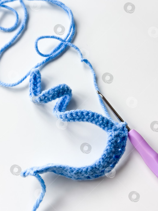 Скачать Синий стежок крючком с фиолетовым крючком на белом фоне фотосток Ozero
