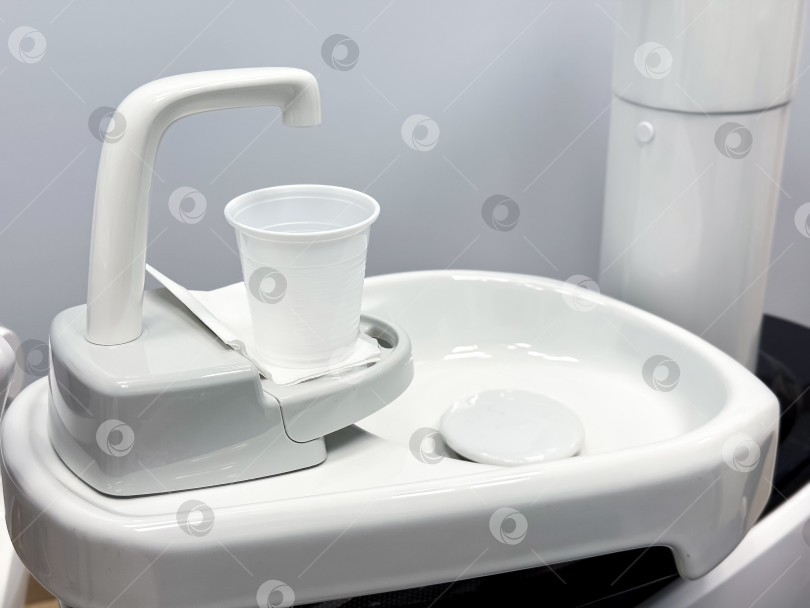 Скачать Современное стоматологическое оборудование с чашкой на белой раковине на сером фоне фотосток Ozero