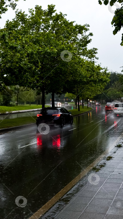 Скачать Дождливая городская улица с машинами и отражающими лужами в пасмурный день фотосток Ozero