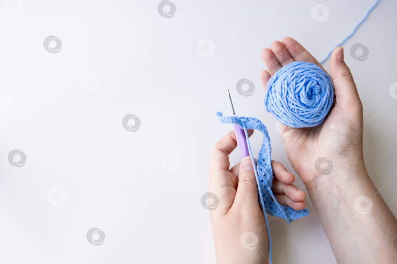 Скачать Ручная работа из синей пряжи и вязального крючка на белом фоне фотосток Ozero