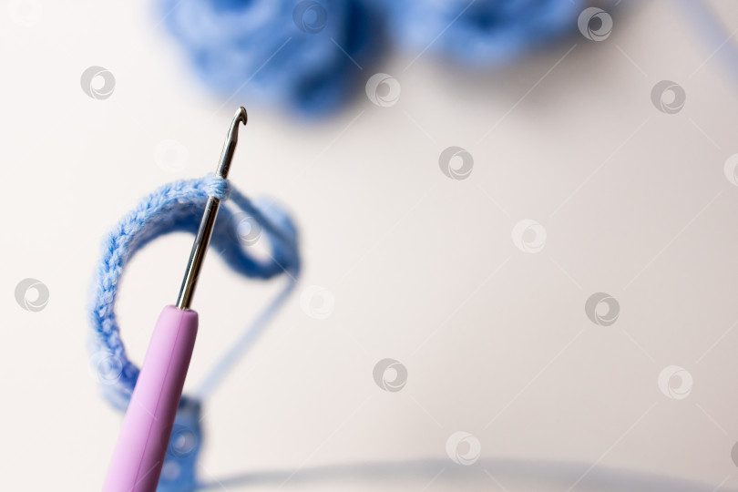 Скачать Крупный план вязального крючка и петли из синей пряжи в сцене рукоделия фотосток Ozero