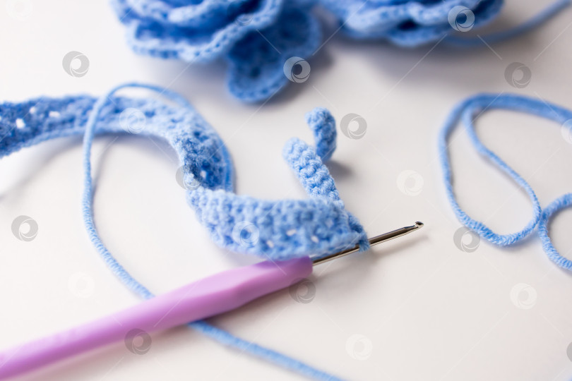 Скачать Крупный план синей вязаной пряжи и крючка на белой поверхности фотосток Ozero