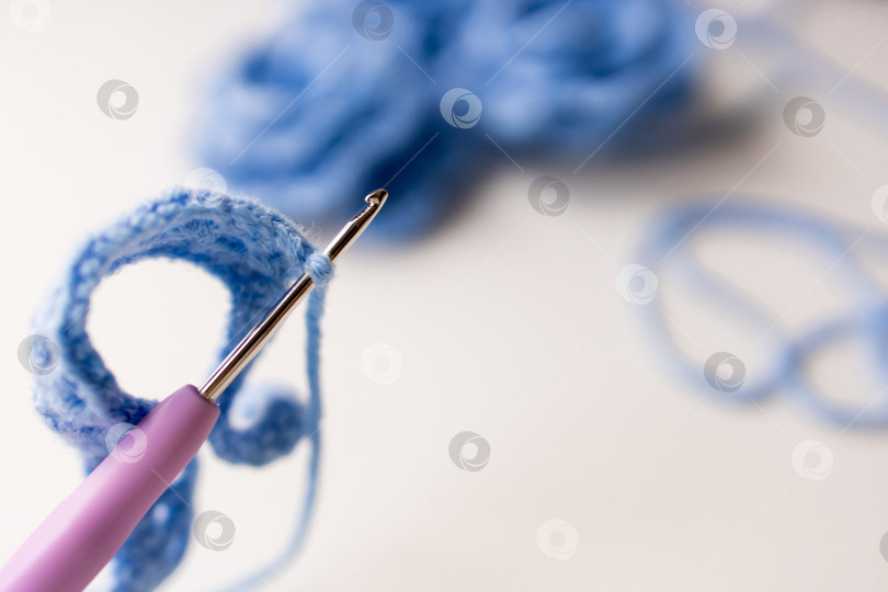 Скачать Крупный план вязального крючка с петлей из синей пряжи в фокусе фотосток Ozero
