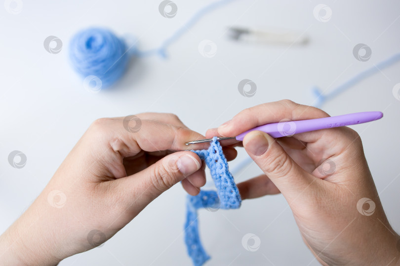 Скачать Взрослая кавказская женщина, связанная крючком фиолетовым крючком и синей пряжей фотосток Ozero