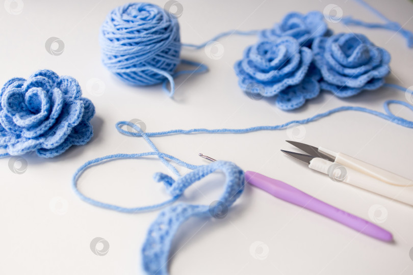 Скачать Синие цветы крючком из пряжи, крючка и ножниц для рукоделия на белом фоне фотосток Ozero
