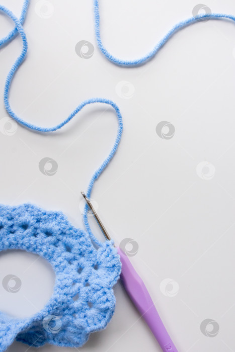 Скачать Синий проект вязания крючком с крючком и пряжей на белом фоне фотосток Ozero