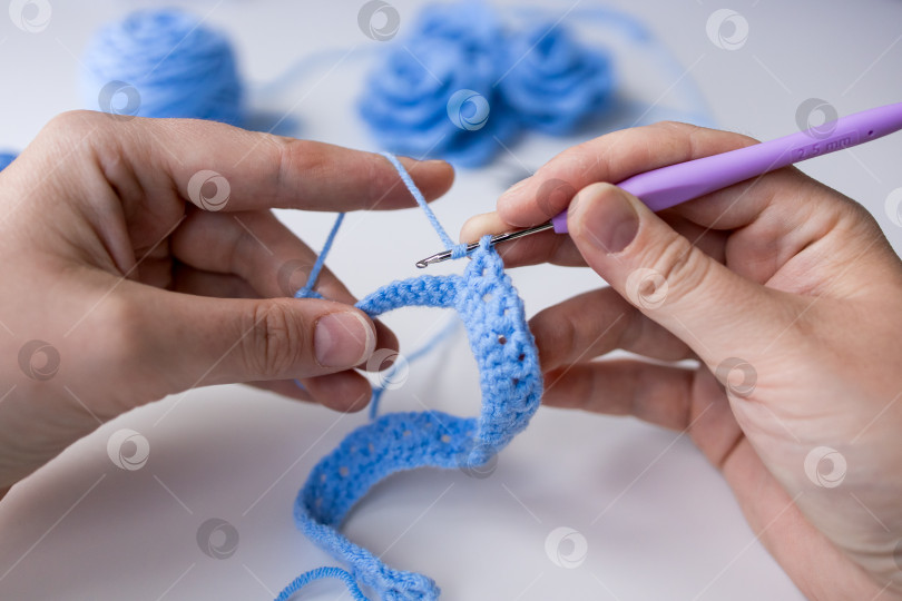 Скачать Крупный план незавершенной работы по вязанию крючком из синей пряжи и крючком для вязания крючком фотосток Ozero