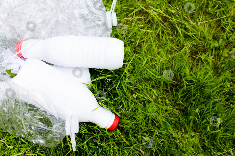 Скачать Пластиковые бутылки на траве. Осведомленность о загрязнении окружающей среды и переработке отходов фотосток Ozero