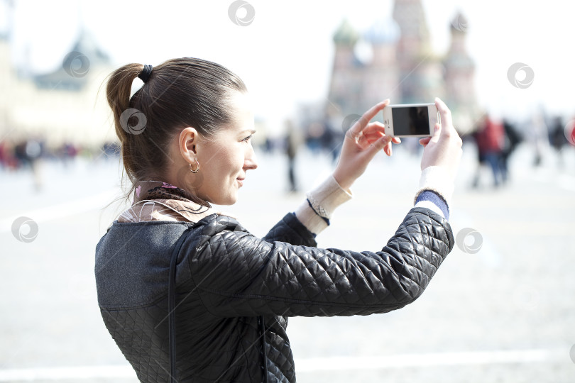 Скачать Молодая женщина фотографирует тебя на телефон фотосток Ozero