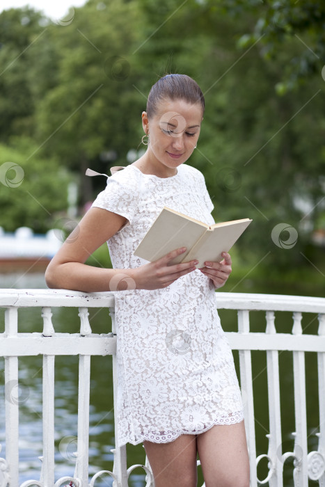 Скачать Брюнетка читает книгу в летнем парке фотосток Ozero