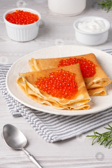 Скачать Вкусные блинчики с красной икрой подаются на уютном столе при дневном свете фотосток Ozero