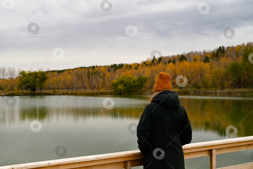 Скачать девушка смотрит на озеро в осеннем лесу с деревянного моста фотосток Ozero