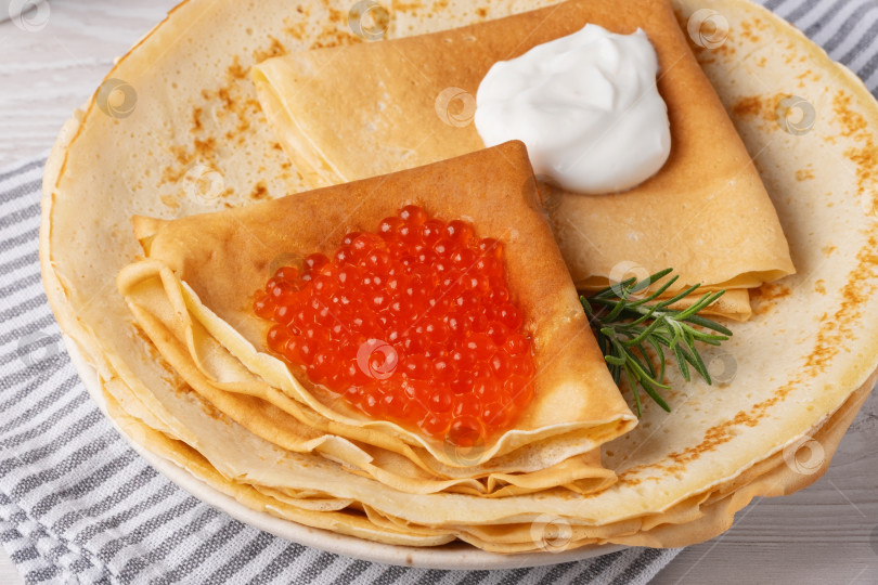 Скачать Вкусные блинчики с красной икрой подаются на уютном столе при дневном свете фотосток Ozero