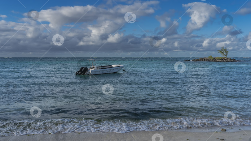 Скачать Моторная лодка стоит на якоре в бирюзовом океане. фотосток Ozero