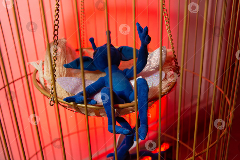 Скачать Причудливая голубая плюшевая игрушка в подвесной клетке. фотосток Ozero