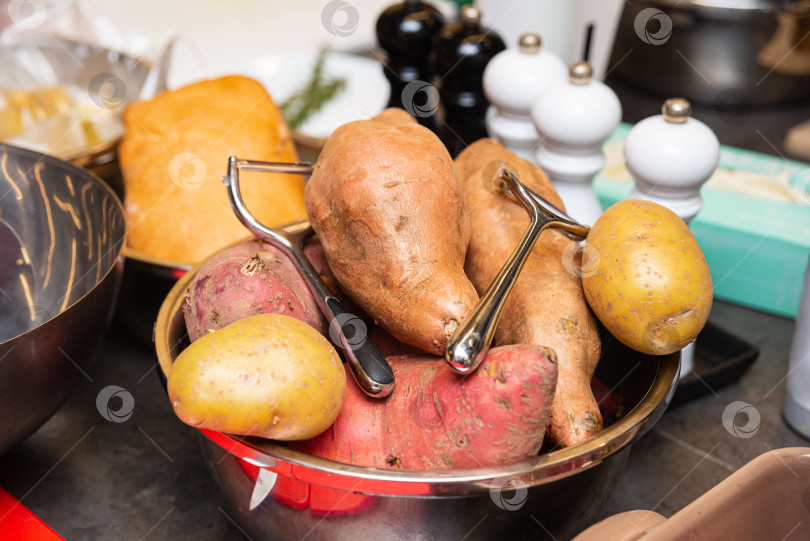 Скачать Сырой сладкий картофель и желтый картофелины выложить в кухонную миску. фотосток Ozero