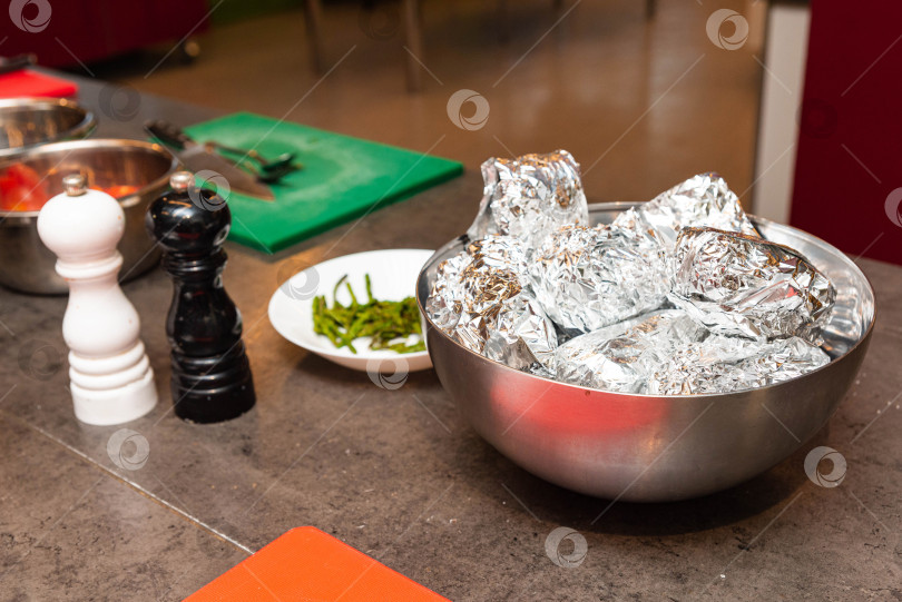 Скачать Порции продуктов, завернутые в фольгу, при приготовлении на кухне. фотосток Ozero