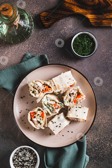Скачать Плоские булочки с курицей и овощами на тарелке, установленной на столешнице в вертикальном положении фотосток Ozero