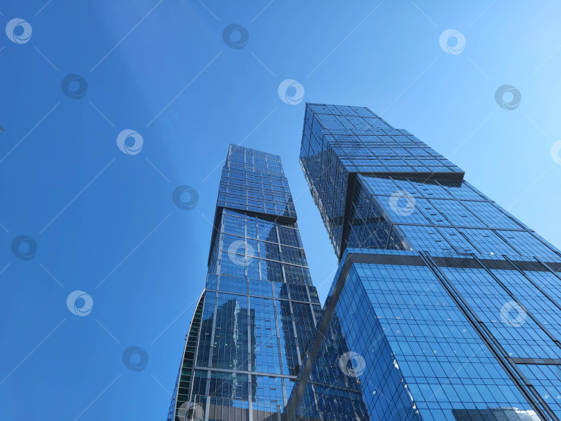 Скачать Москва, Россия, 09.10.2024 г. Стеклянные башни делового района Москва-Сити возвышаются на фоне голубого неба. Современная архитектура, фон. фотосток Ozero