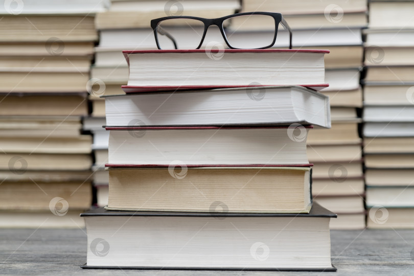 Скачать Очки на фоне книг. Символ знаний, науки, учебы, мудрости. фотосток Ozero