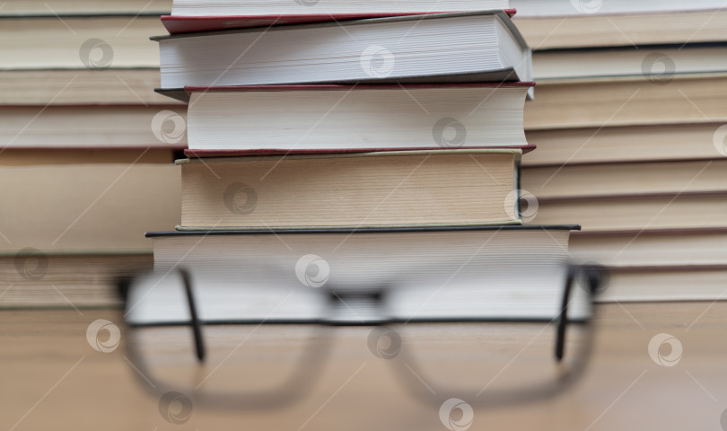 Скачать Очки на фоне книг. Символ знаний, науки, учебы, мудрости. фотосток Ozero