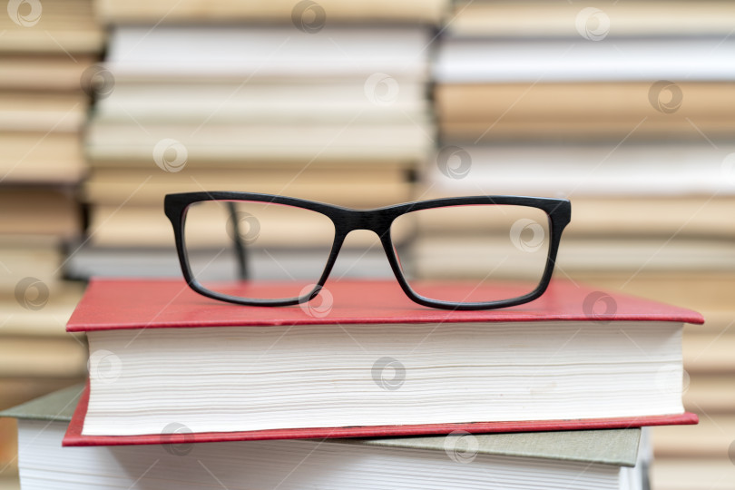 Скачать Очки на фоне книг. Символ знаний, науки, учебы, мудрости. фотосток Ozero