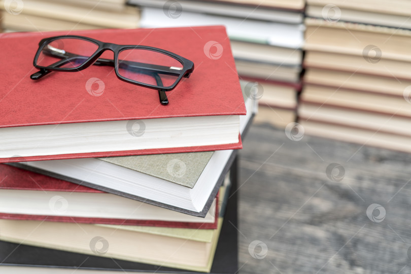 Скачать Очки на фоне книг. Символ знаний, науки, учебы, мудрости. фотосток Ozero