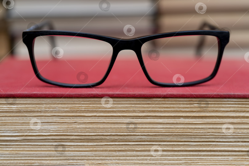 Скачать Очки на фоне книг. Символ знаний, науки, учебы, мудрости. фотосток Ozero