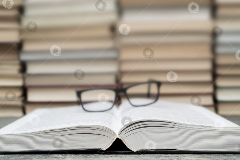 Скачать Очки на фоне книг. Символ знаний, науки, учебы, мудрости. фотосток Ozero