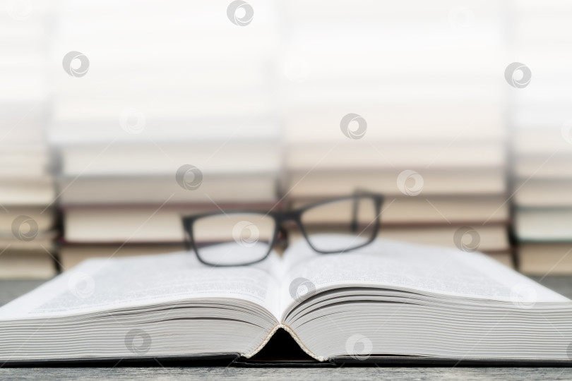 Скачать Очки на фоне книг. Символ знаний, науки, учебы, мудрости. фотосток Ozero