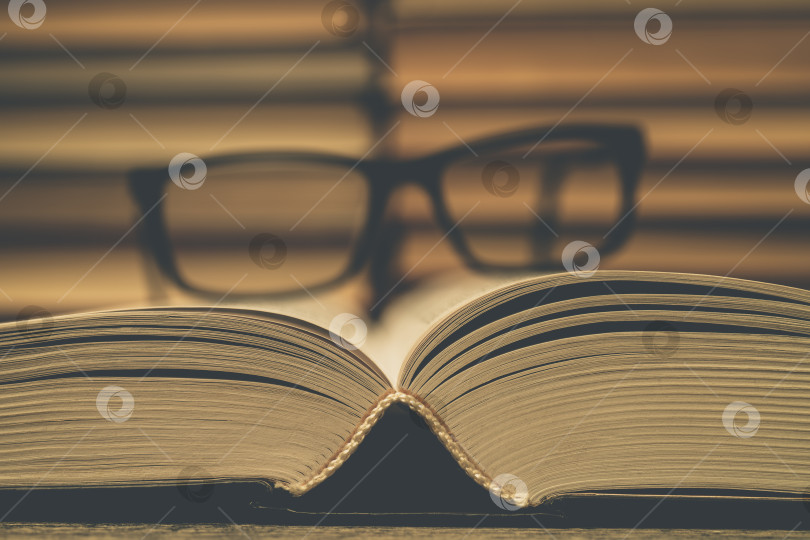 Скачать Очки на фоне книг. Символ знаний, науки, учебы, мудрости. фотосток Ozero