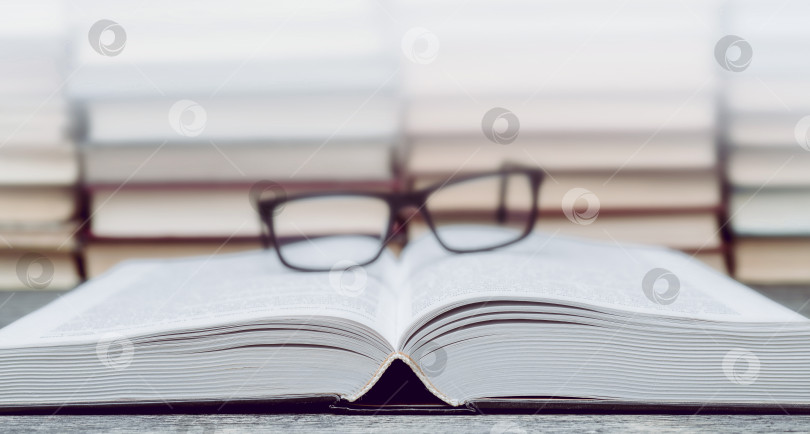 Скачать Очки на фоне книг. Символ знаний, науки, учебы, мудрости. фотосток Ozero