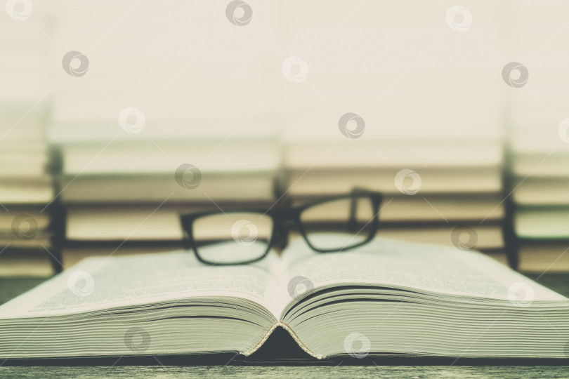 Скачать Очки на фоне книг. Символ знаний, науки, учебы, мудрости. фотосток Ozero
