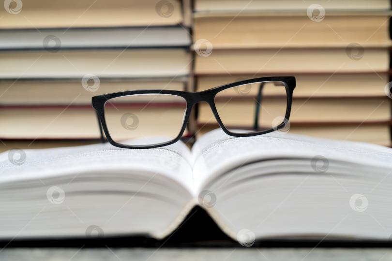 Скачать Очки на фоне книг. Символ знаний, науки, учебы, мудрости. фотосток Ozero