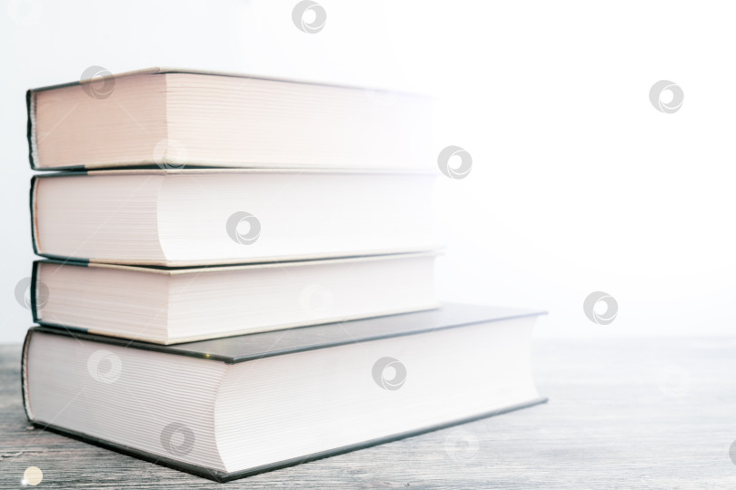 Скачать Толстые бумажные книги - символ образованности и мудрости. Стопка книг на столе. Хранение и распространение информации. фотосток Ozero