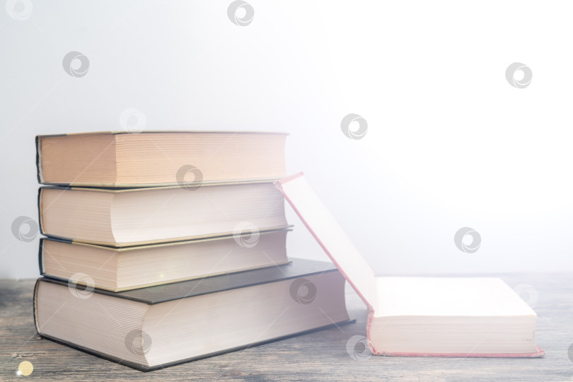 Скачать Толстые бумажные книги - символ образованности и мудрости. Стопка книг на столе. Хранение и распространение информации. фотосток Ozero