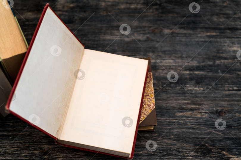 Скачать Толстые бумажные книги - символ образованности и мудрости. Стопка книг на столе. Хранение и распространение информации. фотосток Ozero