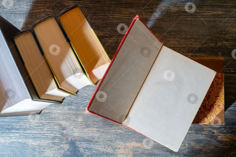 Скачать Толстые бумажные книги - символ образованности и мудрости. Стопка книг на столе. Хранение и распространение информации. фотосток Ozero