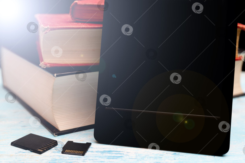 Скачать Современная электронная книга. Маленькие карты памяти. Старые бумажные книги. фотосток Ozero