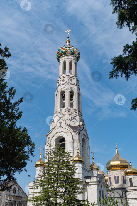Скачать Красивая колокольня с разноцветным куполом возвышается над окружающими деревьями на фоне безмятежного пейзажа - Ставрополь, Россия, 29 мая 2025 года фотосток Ozero