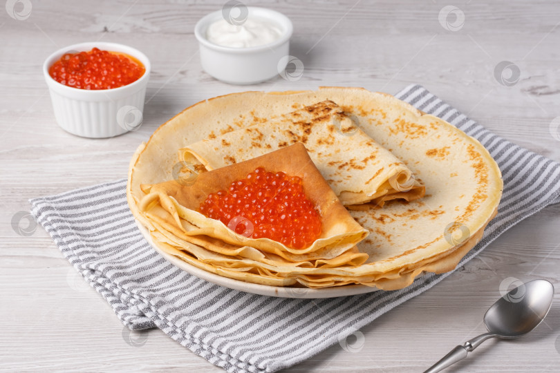 Скачать Вкусные блинчики с красной икрой подаются на уютном столе при дневном свете фотосток Ozero